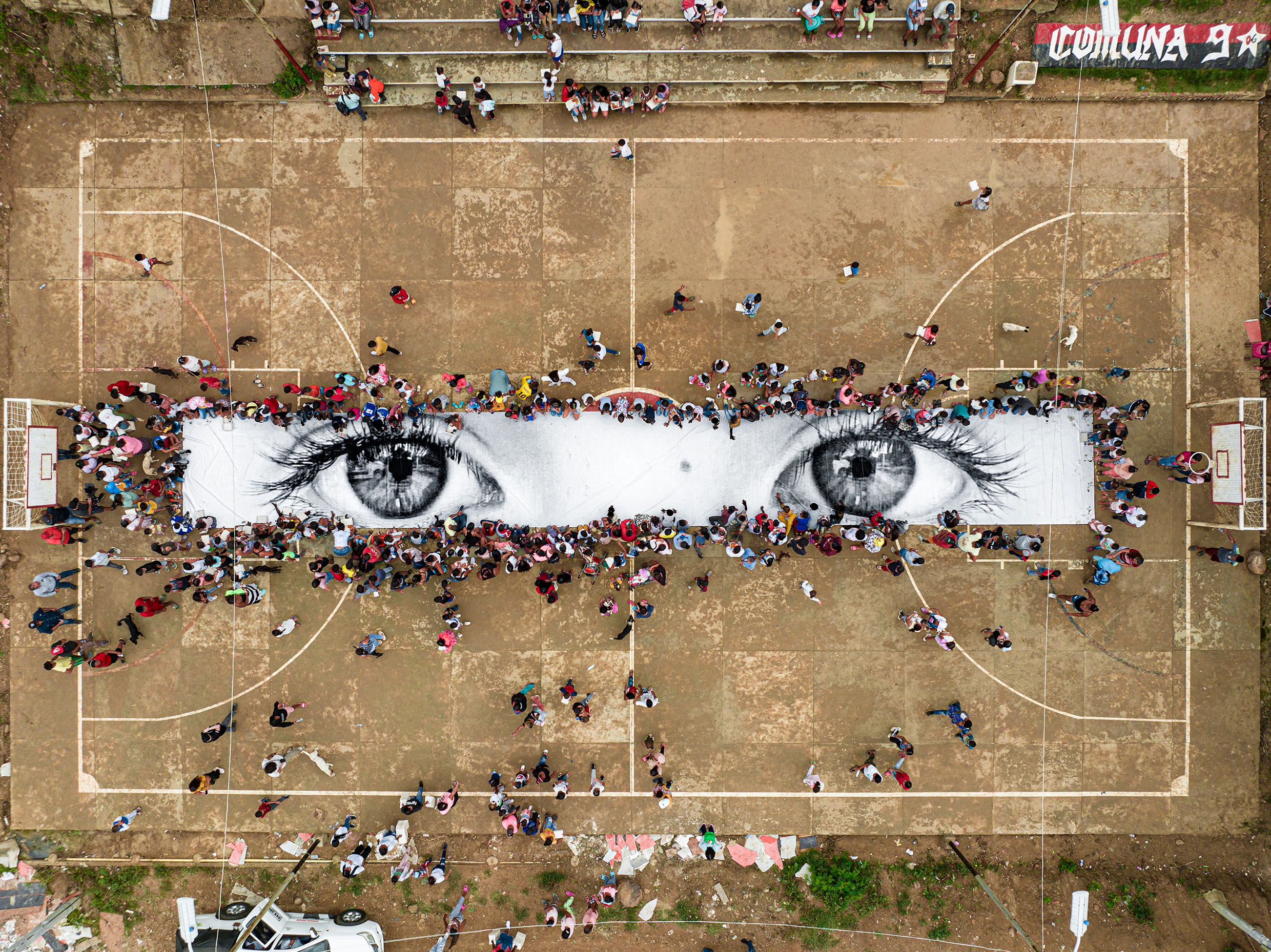 Ett stort konstverk på marken där två ögon tittar uppåt.  