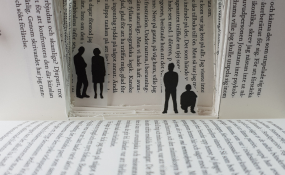 Inuti en bok är ett litet rum skapat där några små figurer befinner sig.