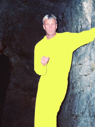 En man i gult lutar sig mot en vägg
