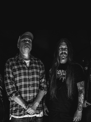 Fyra män poserar i mörker