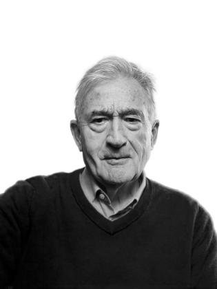 Äldre man med grått hår i skjorta och mörk tröja, porträtt i svartvitt mot vit bakgrund.