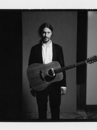 Svartvitt foto på en man med en gitarr