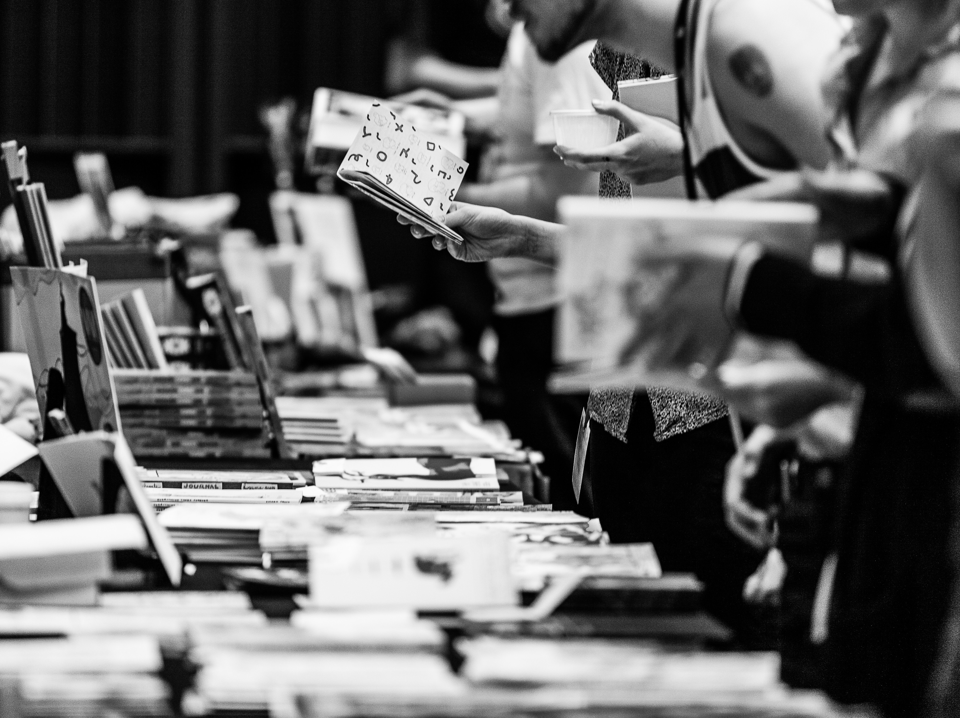 Bokbord på Seriefestivalen och besökare som tar upp och bläddrar i böcker.