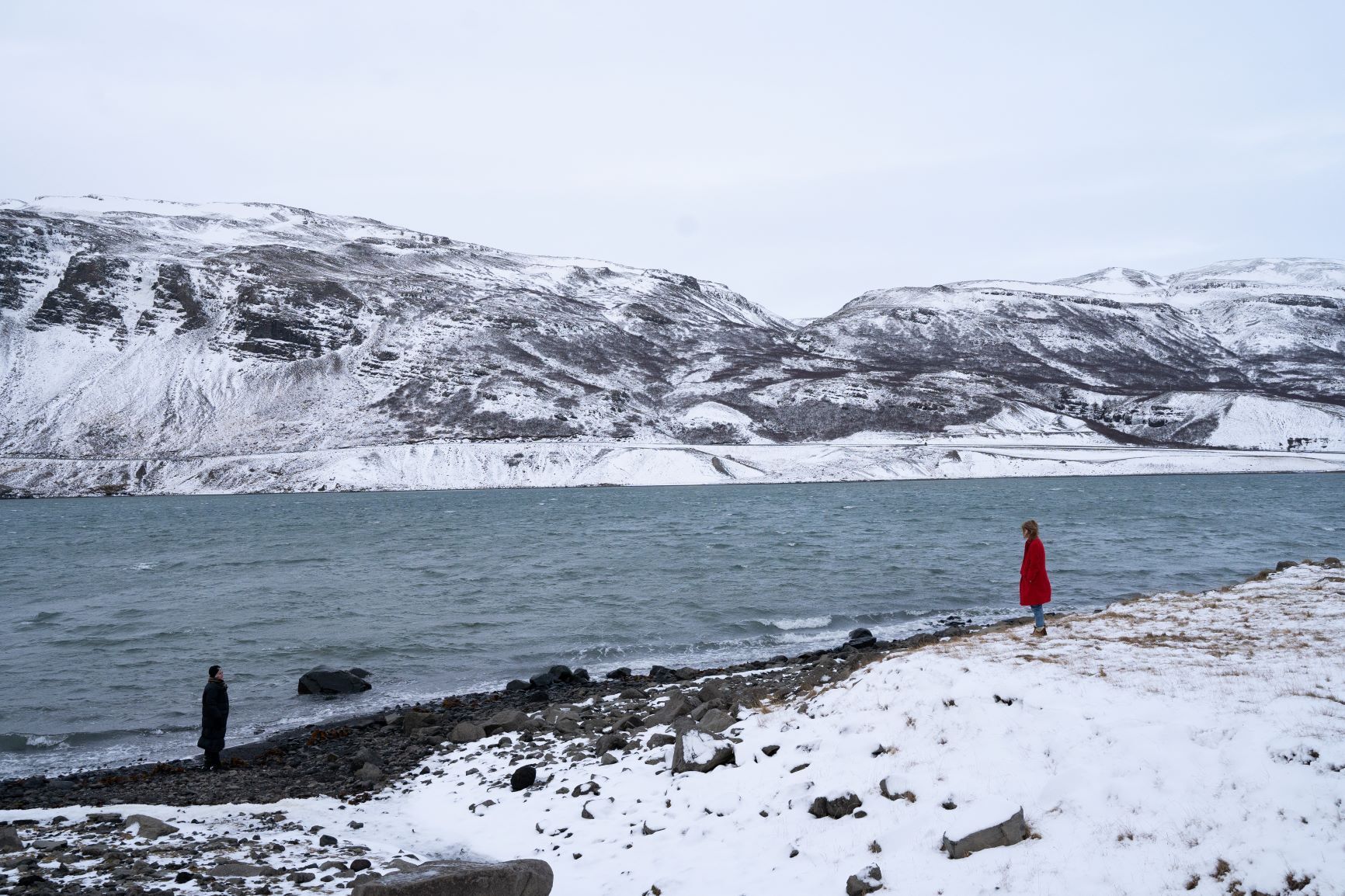 En flicka i röd kappa står i ett snölandskap