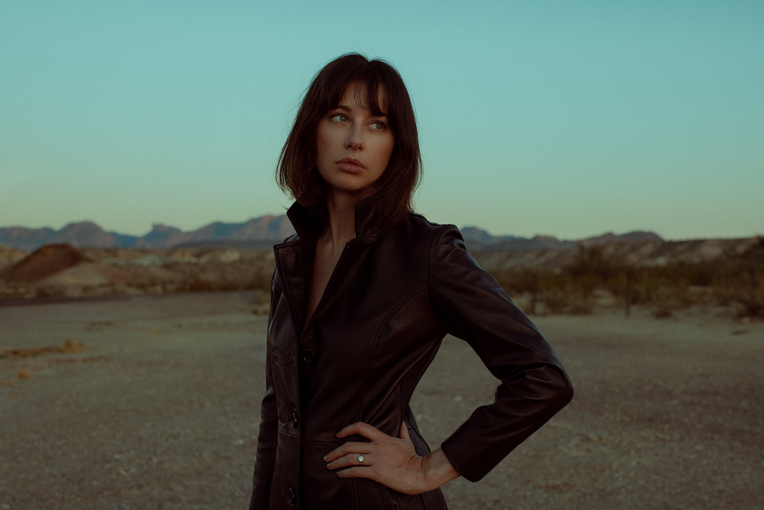 En kvinna i svart jacka i ökenlandskap