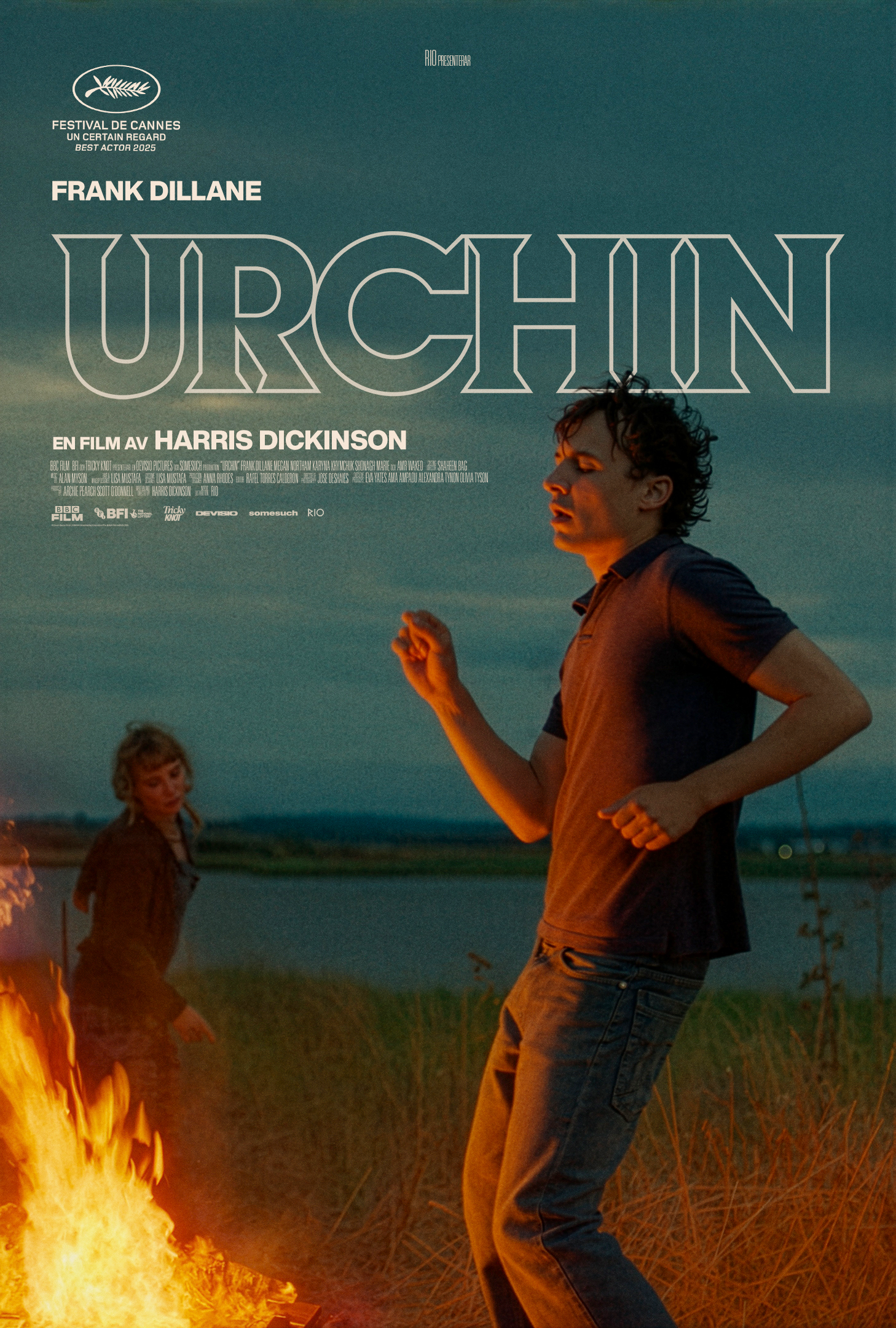 En ung man dansar framför en brasa.