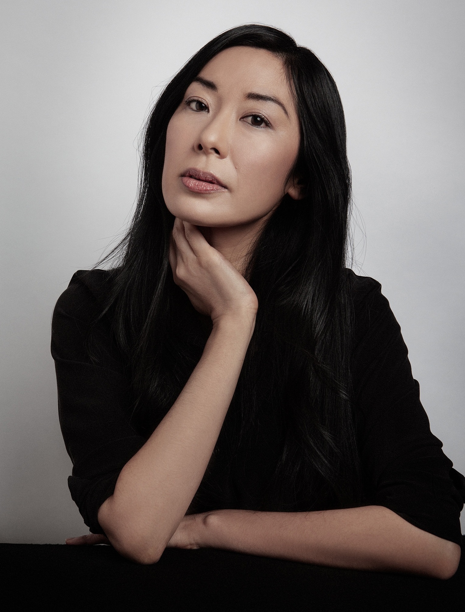Katie Kitamura porträtteras i ett stilla och elegant studioporträtt där den mjuka blicken och den enkla bakgrunden skapar en känsla av koncentration och närvaro.