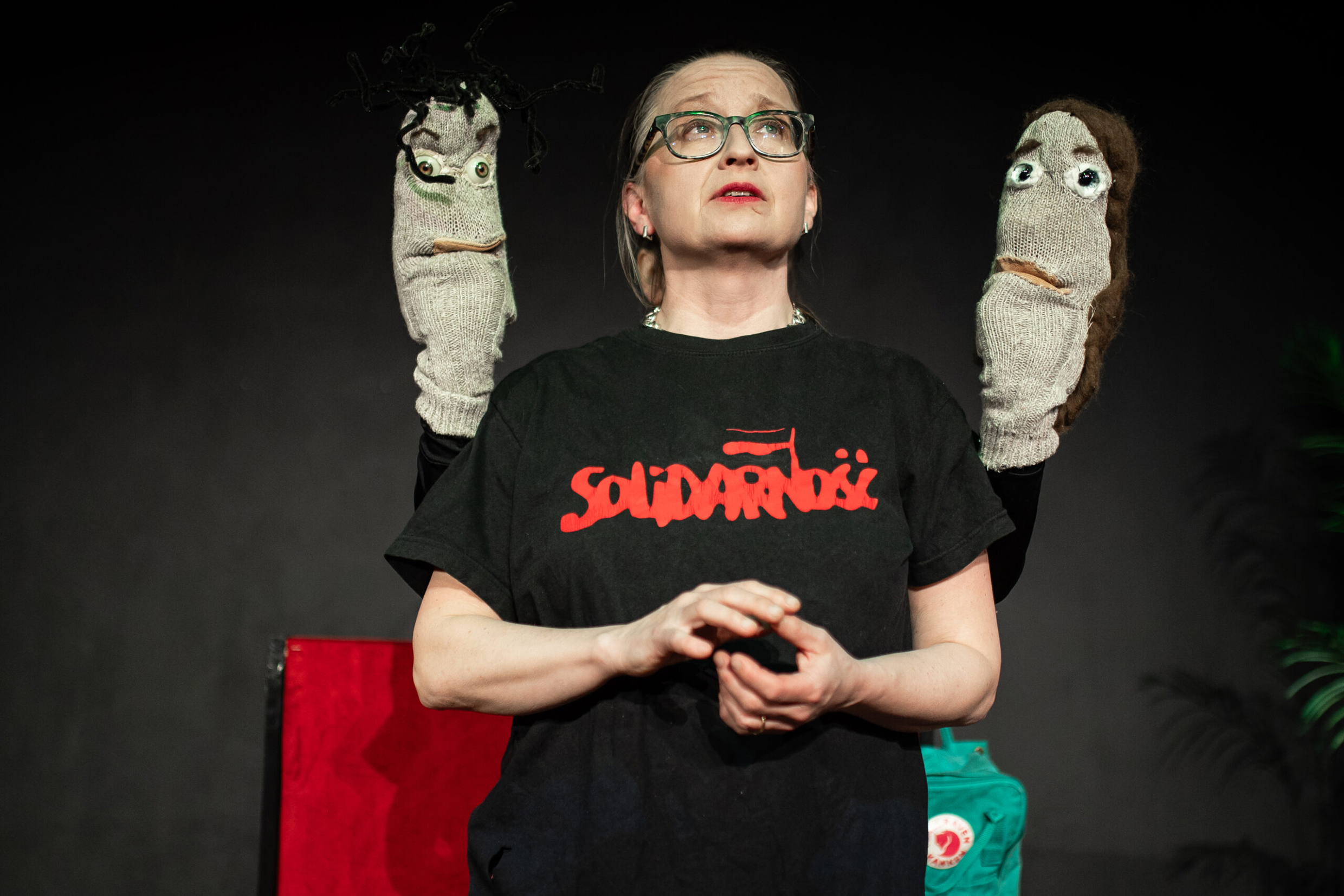 Gertrud Lartsson med två strumpdockor på varsin sida.