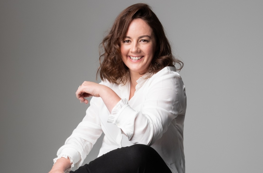 En skrattande kvinna i vit skjorta