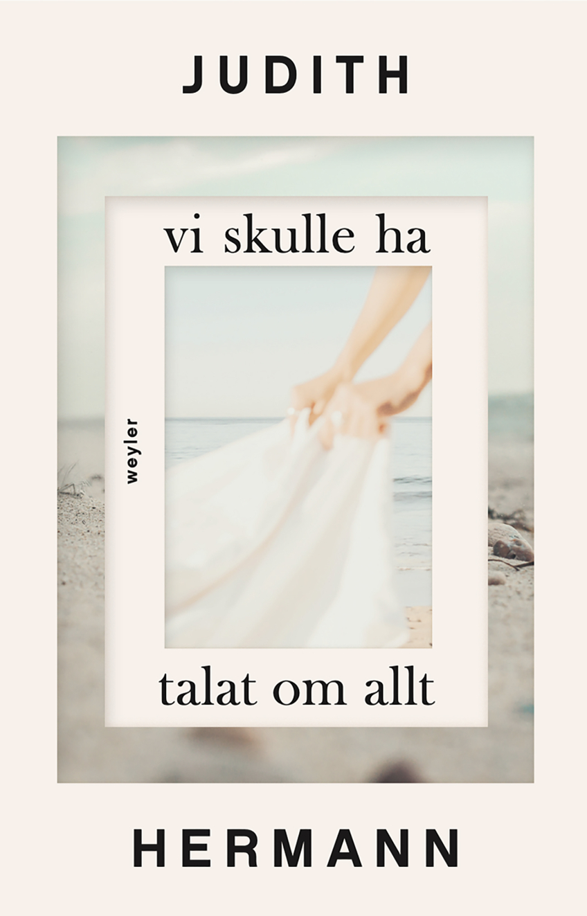 Omslag till boken Vi skulle ha talat om allt av Judith Hermann, med suddig bild av händer som håller i ett vitt tyg vid havet.