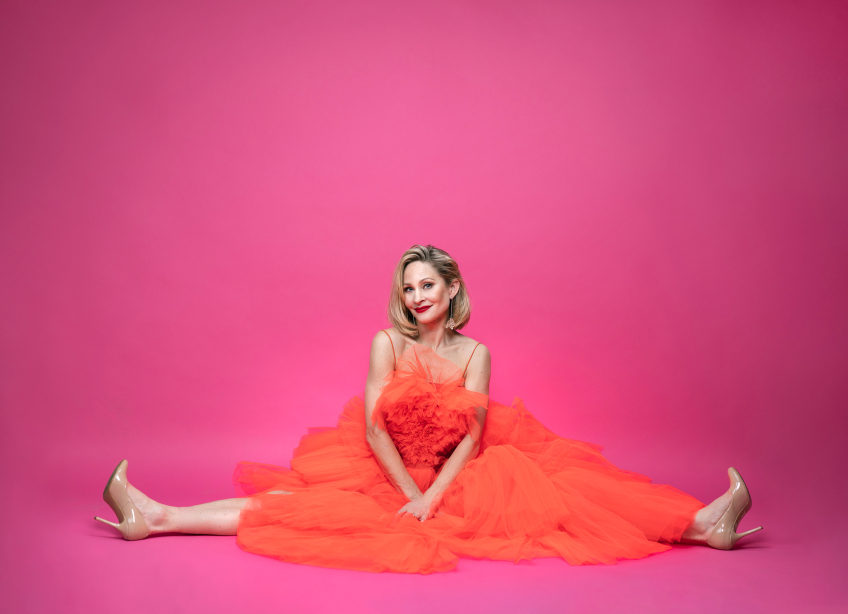 Hanna Lindblad von Spreti  sitter i spagat i en orange klänning