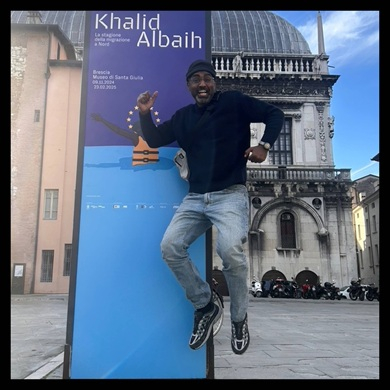 Person hoppar framför en skylt på ett torg med en kyrkobyggnad i bakgrunden.