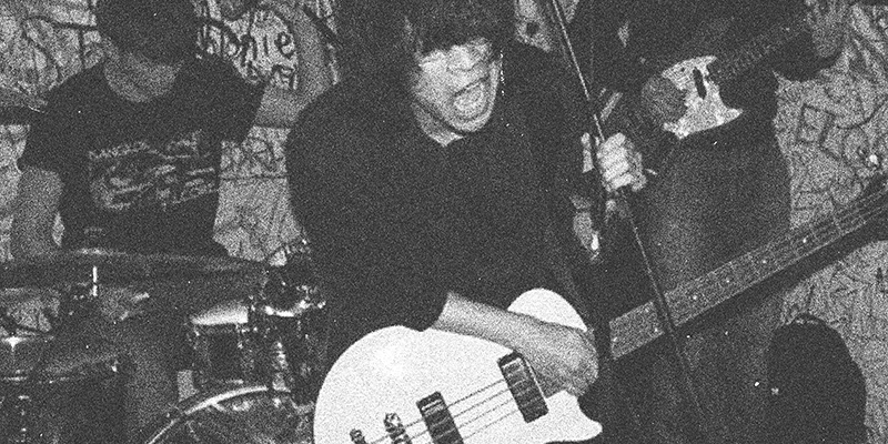 Svartvit bild på kille med gitarr