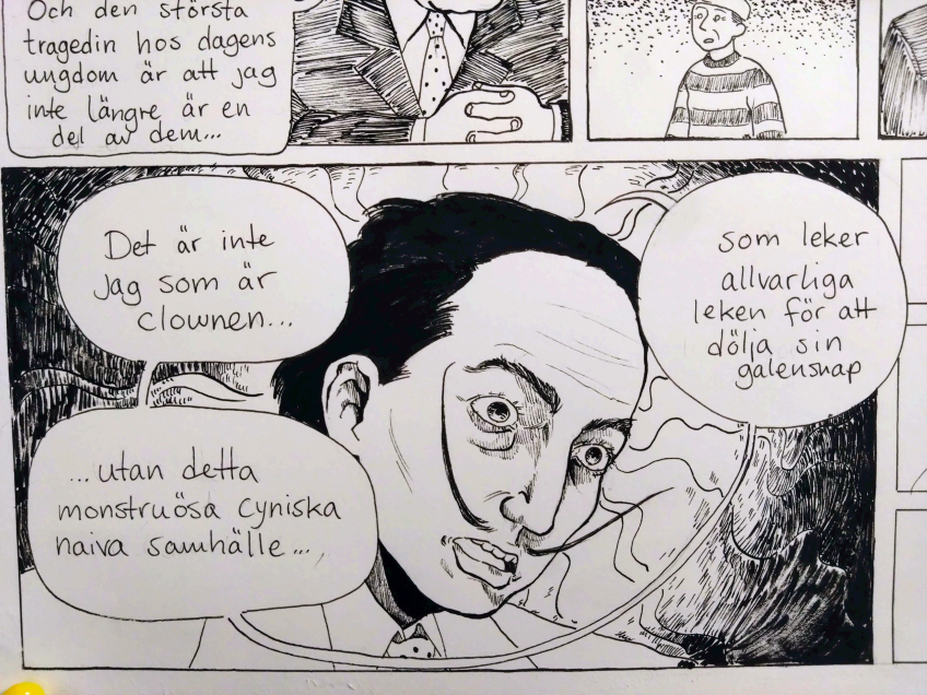 Svartvit serieteckning av en person med stora ögon omgiven av pratbubblor med handskriven text om clownen, samhället och galenskap.