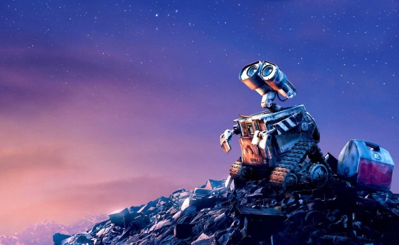 WALL-E står på en sophög och ser upp mot himlen. 
