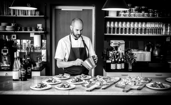 En kock förebereder mat på kafé Trapphuset