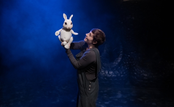 En person på scen håller i en kanindocka. 