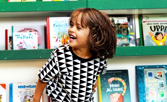 Ett barn med kläder i svartvitt triangelmönster.