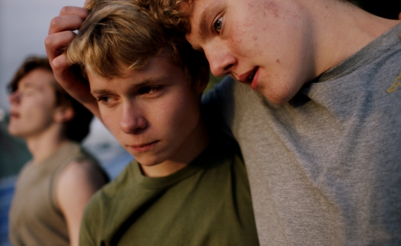 Två killkompisar håller om varandra i närbild