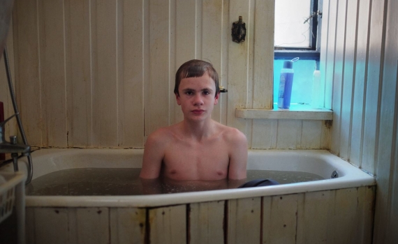 En ung kille sitter i ett badkar