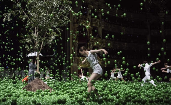 Balettdansare på scen i ett hav av gröna bollar