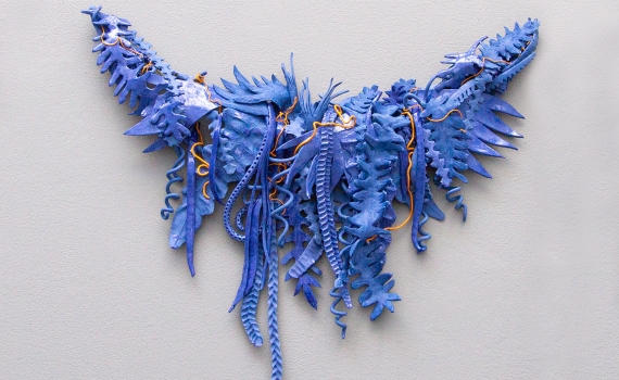 Ett konstverk som tycks vara skapat av blad och växter målade i blå färger. 