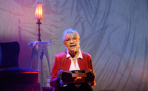 Iwa Boman bland en massa kassettband med en bandspelare i knät.