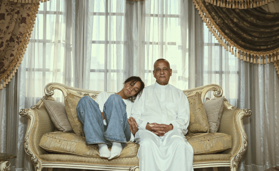 Ung kvinna lutar huvudet mot äldre man i soffa