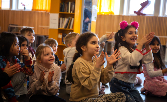 Glad engagerade förskolebarn som tittar på teater