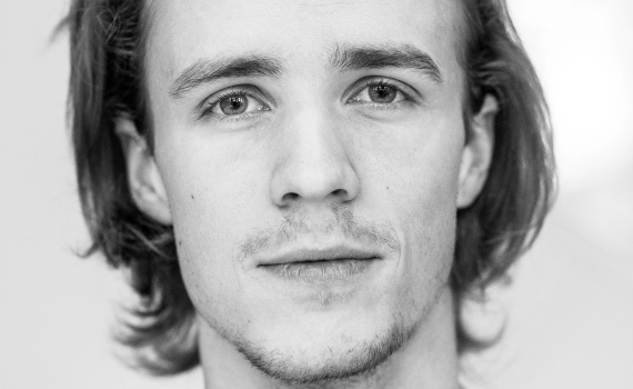 Porträttfoto på skådespelaren Oskar Laring.  