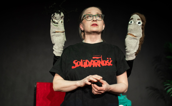 Gertrud Lartsson med två strumpdockor på varsin sida.