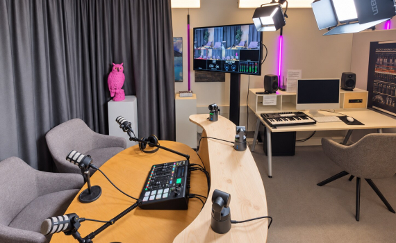 Översikt av Lava Studio med poddbord, mikrofoner, kameror och arbetsstation för musikproduktion. 