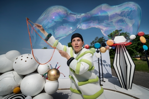 En koncentrerad skådespelare, från Marionetteatern, skapar en stor såpbubbla. 