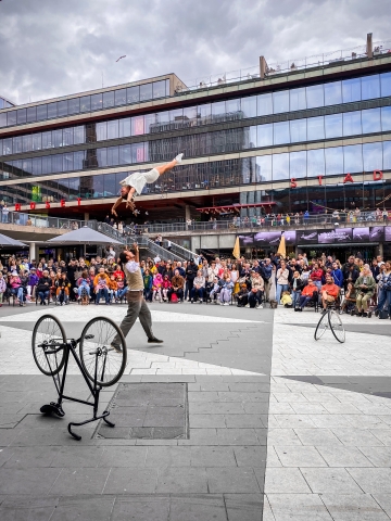 Cirkusartister som utför akrobatik framför publik på Sergels torg