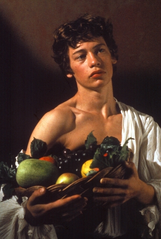 Porträtt av en ung man somm håller i en fruktkorg