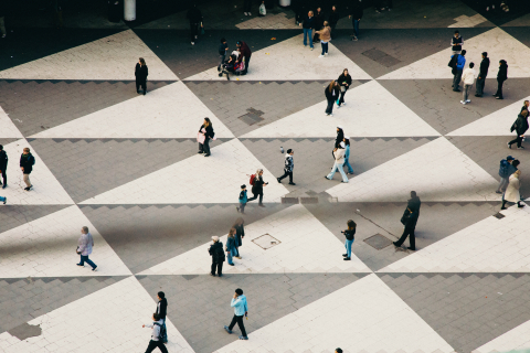 Flygbild över Sergels torg med rutmönster och många gående personer i olika åldrar och kläder.
