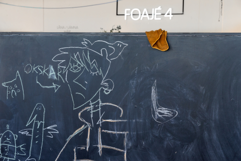 Svart tavla med kritteckningar av figurer och texten "OKSKAR", i rum märkt "Foajé 4".