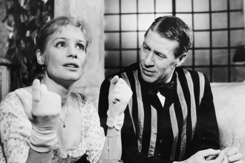 Svartvitt foto på två skådespelare i sekelskifteskostymer.