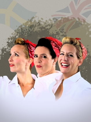 Tre kvinnor i vita skjortor och rödvita halsdukar runt håret. I bakgrunden anas en svenksk och en brittisk flagga