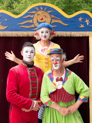 Clownen Manne och hans två barn Olle och Maria framför scenografi
