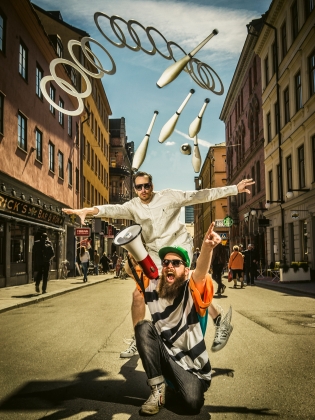 En jonglör och en person med en megafon på en gata