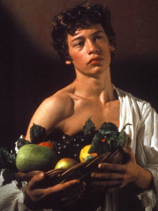 Porträtt av en ung man somm håller i en fruktkorg