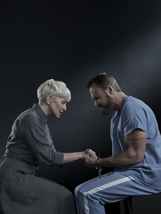 En nunna och en fånge håller varandras händer