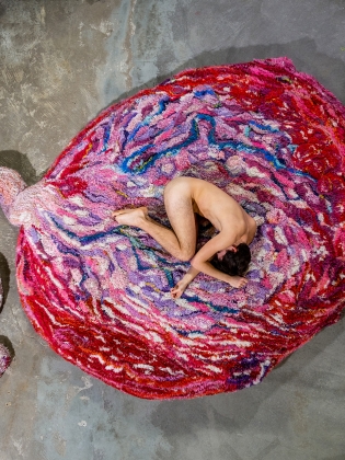 Konstverket Kött och blod, där en naken person ligger på en sorts matta, inspirerad i färg och form av en moderkaka.