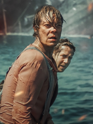 Två män står vid ett brinnande krigsfartyg
