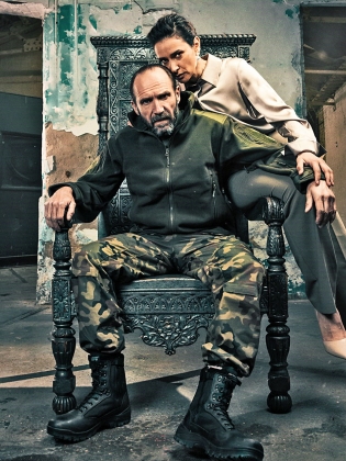 En uniformerad man sitter på en tron med en kvinna som lutar sig mot honom
