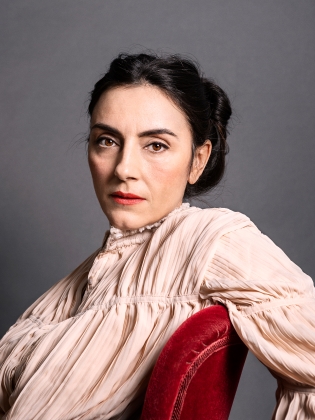 Linda Bonaventura sitter på en stol med armen vilandes på ryggstödet