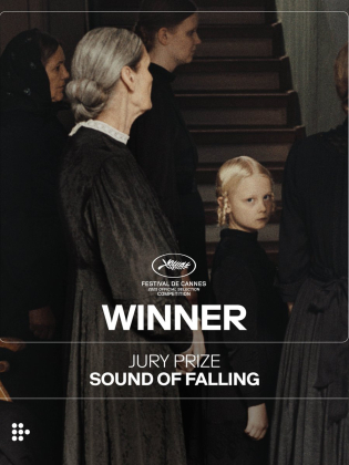 En liten svartklädd flicka ser dystert mot kameran.