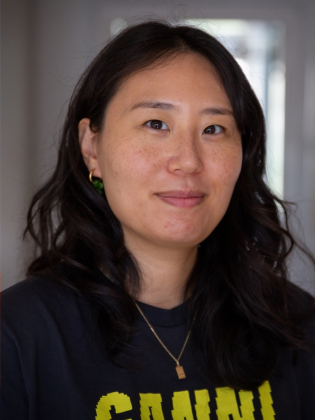 Tre personer cirka 30-40 år: en i beige linne med orange plagg, en i svart tröja med halsband, en i orange stickad tröja.