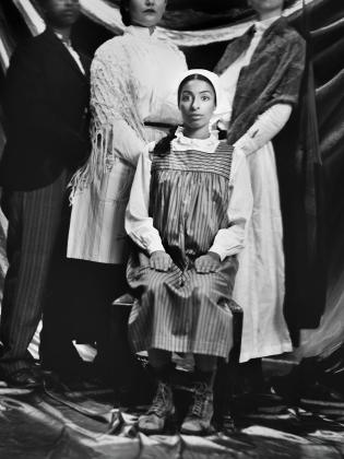 Svartvit bild i äldre stil av familj där en ung kvinna ser chockad ut.